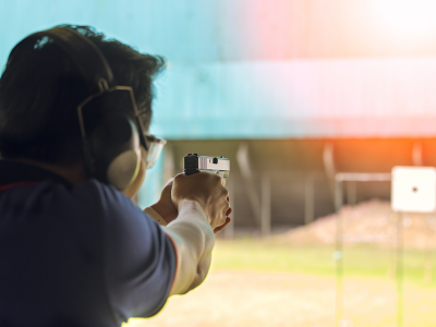 Image of a man shooting at a target at a shooting range.