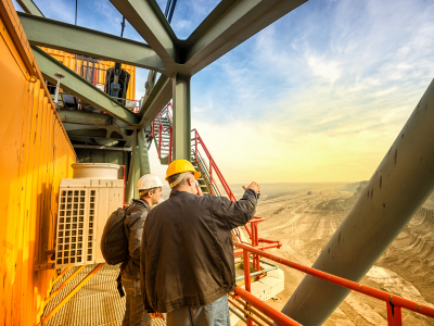 Two workers standing at the top of a mine site.