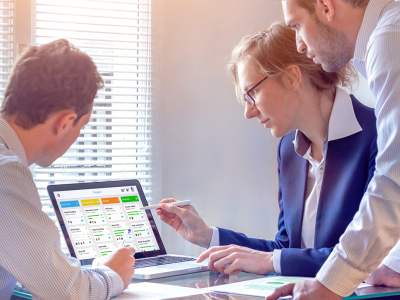 Three business people looking at a chart on a laptop