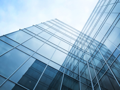 Image of the corner of two buildings, showing their reflections in the glass