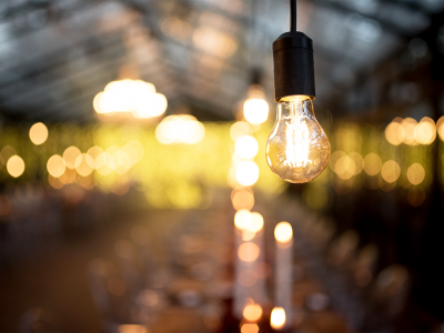 Image of a lit light bulb in front of a blurred background