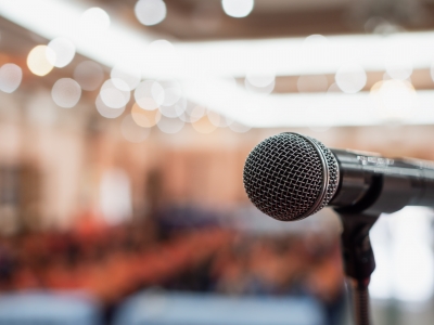 Image of a microphone on stage in front of conference