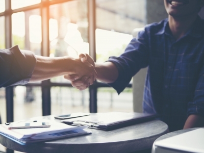Two people shaking hands at a desk