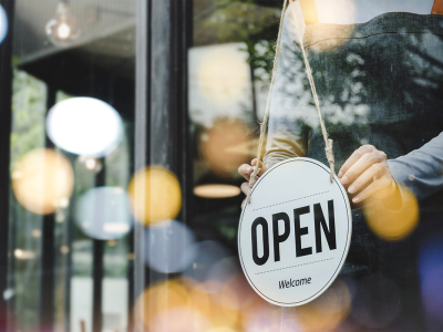 Image showing a person placing an open sign in a window