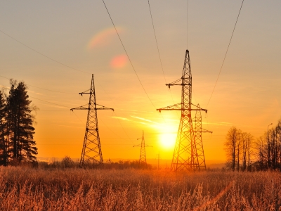 Image of power transmission lines across a field in Queensland at sunset