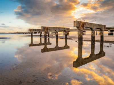 Sunrise over jetty water reflections