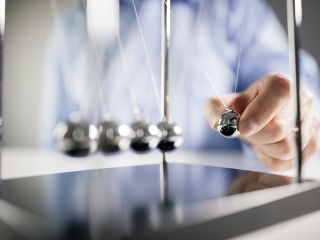 Image of a person with a Newton's cradle