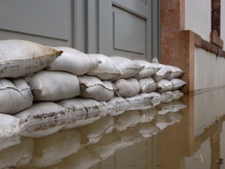 Image of sandbags against a doorway with flood waters