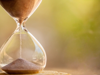 Close-up photo of sand running through hourglass