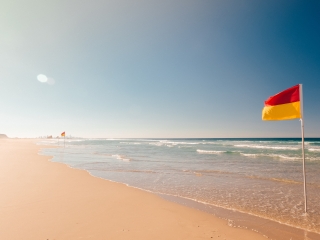 Blog thumbnail: beach with red and yellow flags