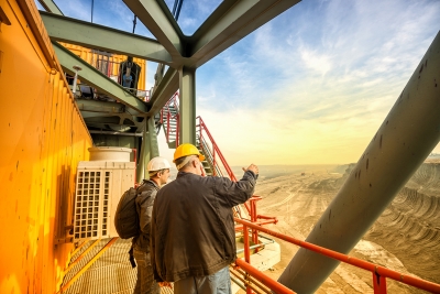 Two workers standing at the top of a mine site.