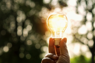 A hand holding a lightbulb