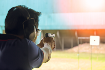 Image of a man shooting at a target at a shooting range.