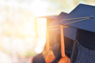 Image of graduates from the back, showing their graduation hats and tassels