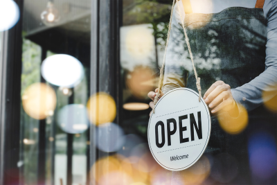 Image showing a person placing an open sign in a window