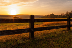 Wooden fence in rural area at sunset
