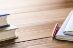 Books, pen and files on a wooden desk